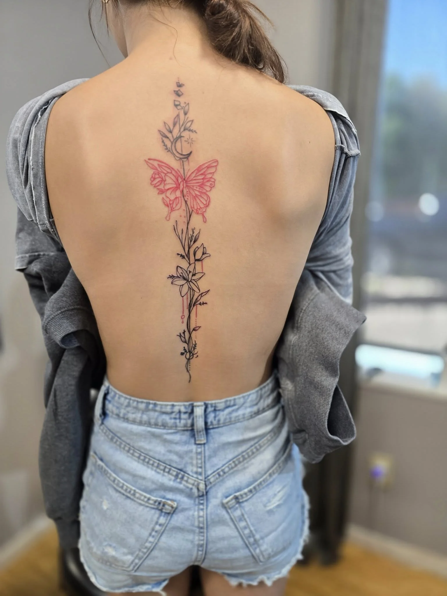 Floral spine tattoo with red flower accent - Color accent spine tattoo Moose Jaw
