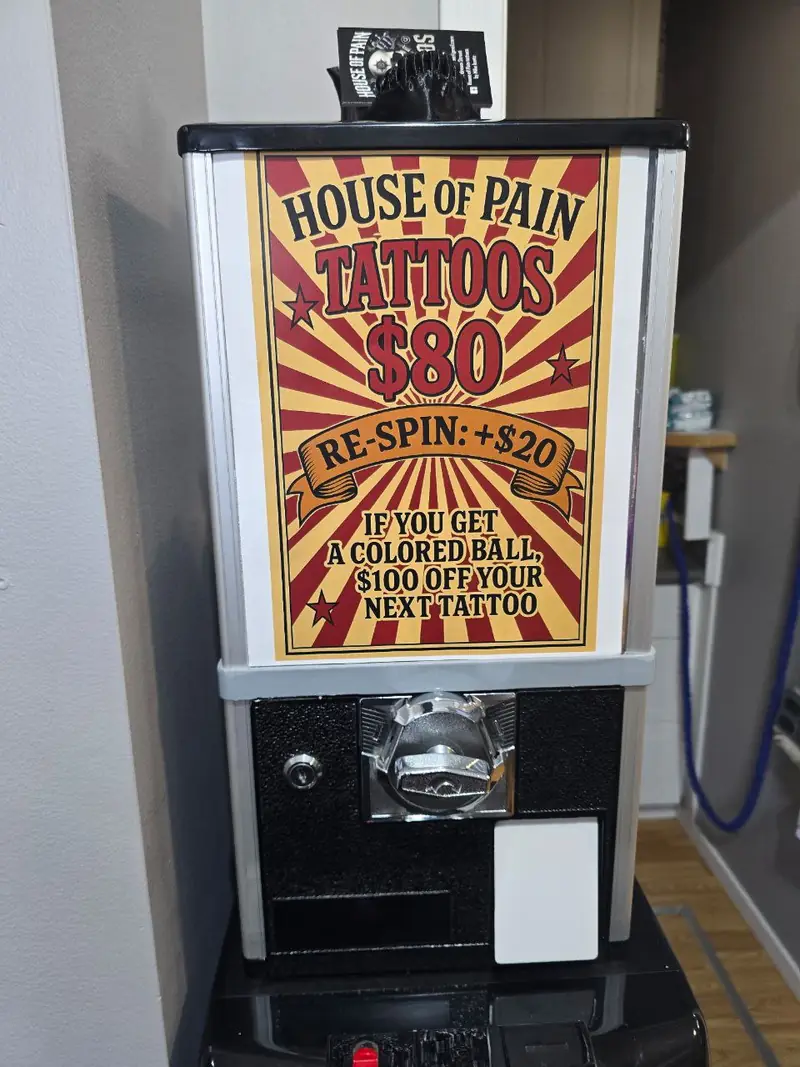 Vintage candy machine repurposed for random tattoo designs at House of Pain Tattoos Moose Jaw